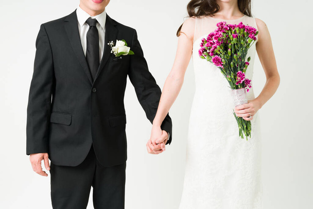 Casarme con el amor de mi vida. Primer plano de una joven novia y novio tomados de la mano en su ceremonia de boda - Foto, Imagen