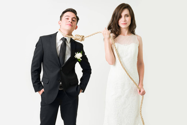 Навсегда вместе. Портрет привлекательной пары, связанной веревкой на свадебной церемонии - Фото, изображение