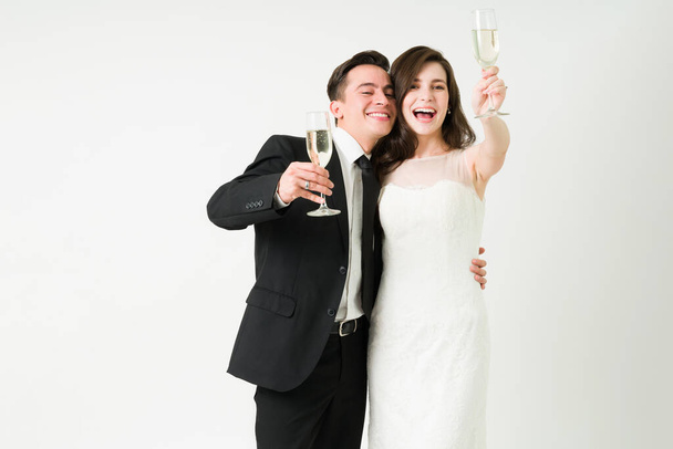 Díky! Portrét vzrušené ženy a ženicha pronášející přípitek se šampaňským při proslovu na jejich svatební hostině  - Fotografie, Obrázek