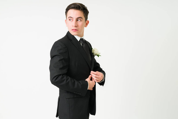 Przygotowuję się do ślubu. Atrakcyjny młody mężczyzna zakłada garnitur na ceremonię ślubną - Zdjęcie, obraz