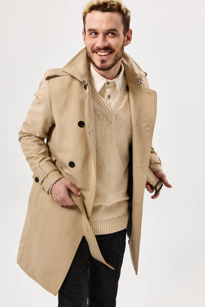Veselý muž v béžové kabát emoce studio moderní styl izolované pozadí - Fotografie, Obrázek