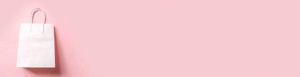 ピンクのパステルを背景にしたミニマルなデザインのショッピングバッグ。オンラインまたはモールのショッピングショップのコンセプト。ブラックフライデークリスマスシーズン販売。フラットレイアウトトップビューコピースペースモックアップバナー - 写真・画像