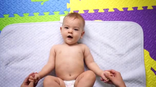Maman secoue et étire les bras du bébé menteur - Séquence, vidéo