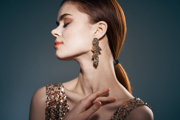 woman in gold dress and earrings jewelry Glamor model - Foto, afbeelding