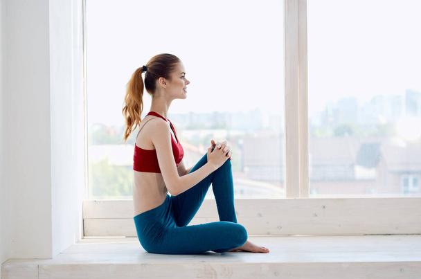 Frau übt in der Nähe von Fenster Yoga-Übung Meditation - Foto, Bild
