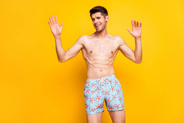 Photo of funky charming young guy shirtless smiling dancing isolated yellow color background - Foto, imagen