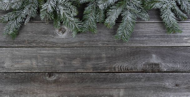 Rami sempreverdi ricoperti di neve, bordo superiore, su assi di legno sbiadite per un buon Natale o un felice concetto di festa di Capodanno  - Foto, immagini