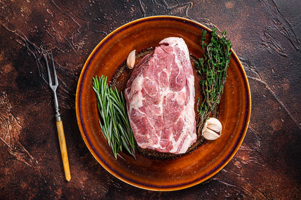 Bife de carne de porco cru fresco no prato rústico. Fundo escuro. Vista superior - Foto, Imagem