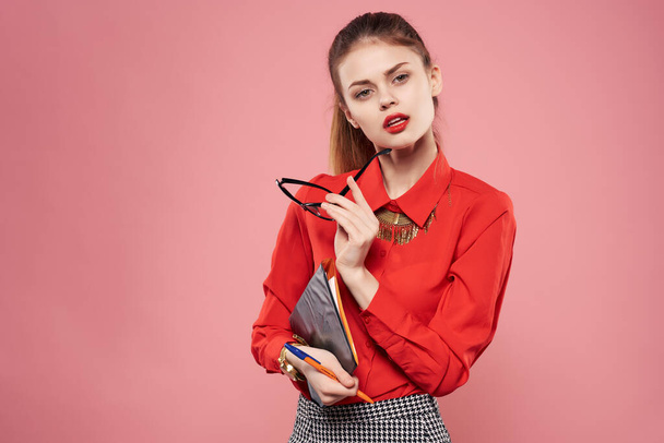 mujer en camisa roja y gafas documentos en manos del secretario de fondo rosa - Foto, Imagen