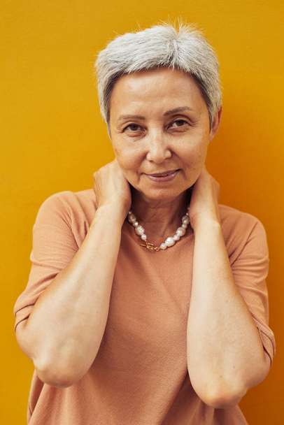 Elegantní starší žena na žluté - Fotografie, Obrázek