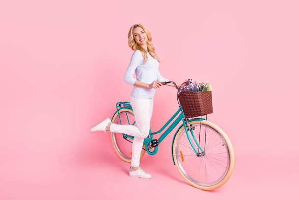 Full size photo of charming happy young woman ride bike spring mood smile isolated on pink color background - Foto, Bild