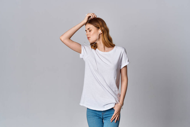 γυναίκα σε λευκό t-shirt μόδας ακούγοντας μουσική απομονωμένο μοντέλο φόντου - Φωτογραφία, εικόνα