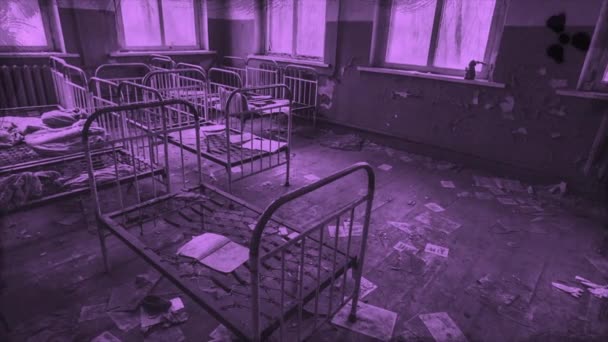 Chambre d'enfants abandonnée à la maternelle, détails d'une ville fantôme aux couleurs violettes, Pripyat, Ukraine. Motion. Flippant vieux lits métalliques pour les enfants à l'intérieur du bâtiment en ruine. - Séquence, vidéo