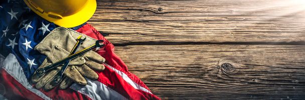  День праці - американський прапор з твердим капелюхом, гайковими ключами та шкіряними рукавичками на дерев'яному тлі
 - Фото, зображення