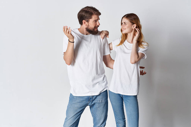 iloinen nuori pari valkoisissa t-paidoissa, jotka aiheuttavat muotia kevyt tausta - Valokuva, kuva
