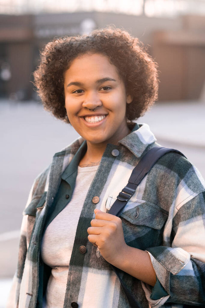 Cheerful teenage student with backpack spending time outdoors - Photo, Image