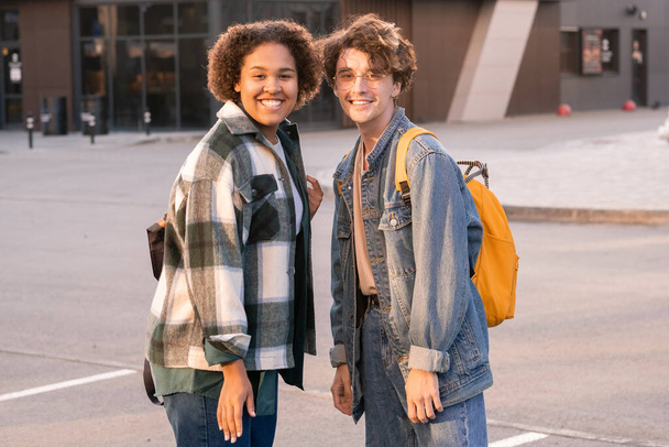 Cheerful teenage couple in casualwear standing close to one another - Photo, image
