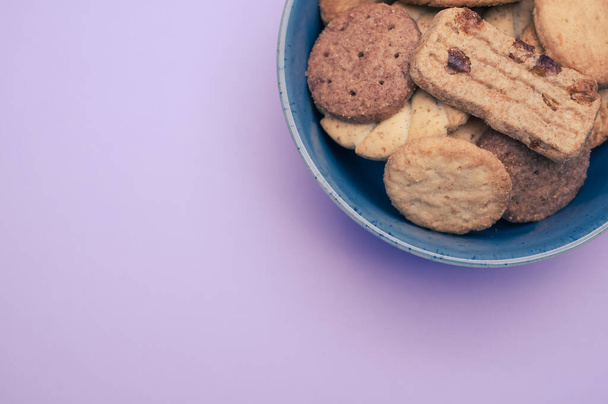 A closeup of a bowl of cookies on the violet background. - Foto, immagini