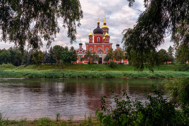 Katedra Zmartwychwstania Pańskiego na brzegu rzeki Polist wczesnym zachmurzonym letnim rankiem, Staraya Russa, obwód nowogród, Rosja - Zdjęcie, obraz
