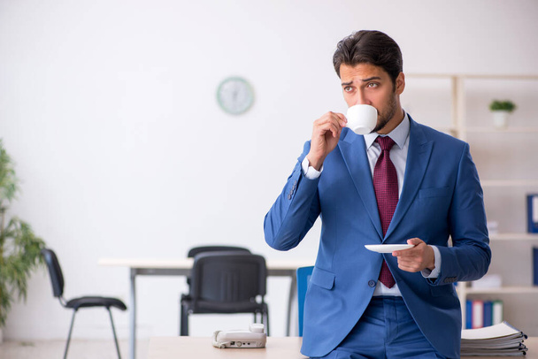 休憩中にコーヒーを飲む若い男性従業員 - 写真・画像
