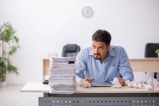 Jonge mannelijke werknemer verwerpt nieuwe ideeën op kantoor - Foto, afbeelding