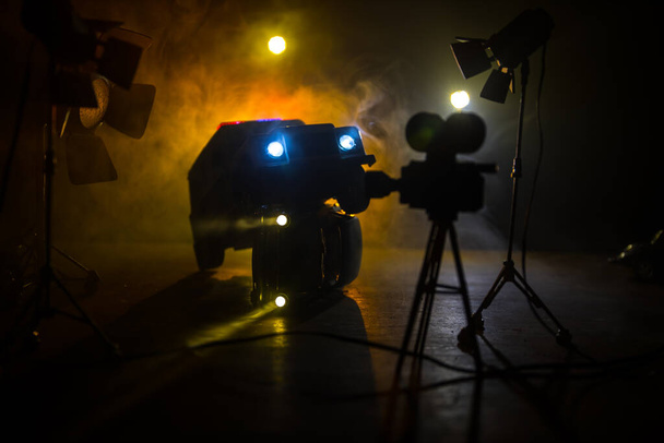 Actionfilm-Konzept. Polizeiautos und Miniaturfilm auf dunkel getöntem Hintergrund mit Nebel. Polizeiwagen verfolgen in der Nacht ein Auto. Tatort Unfall. Selektiver Fokus - Foto, Bild