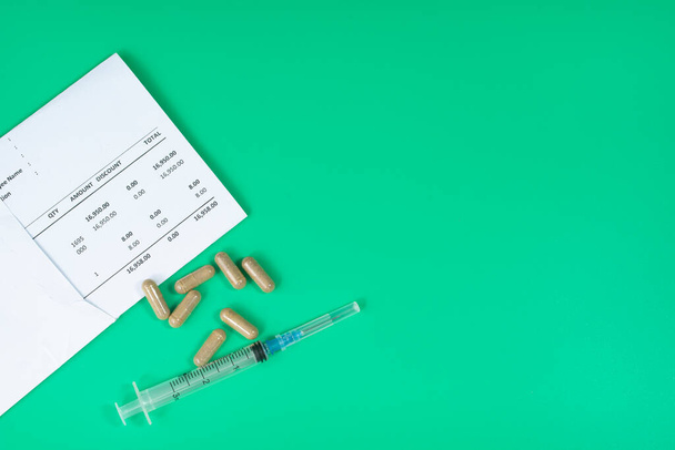 Medical and business concept. Layout of medical bills, syringe and pills. Selective focus points - Φωτογραφία, εικόνα