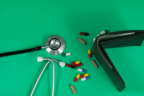 Medical and business concept. Layout of stethoscope, pills and wallet with cash reference to medical bills. Selective focus points - Photo, Image