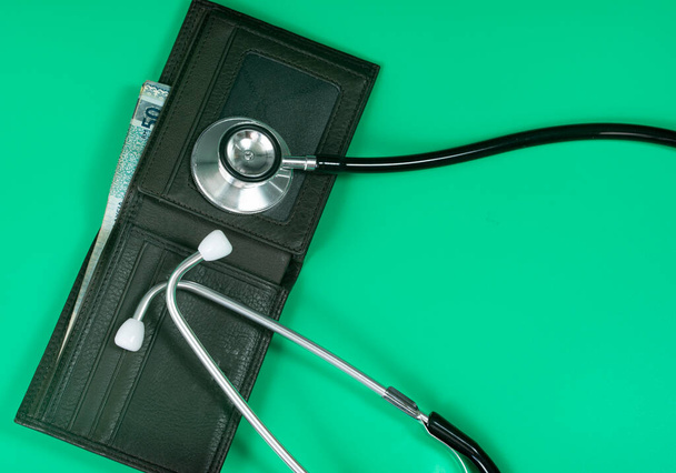 Koncepcja medyczna i biznesowa. Układ stetoskopu i portfela z odniesieniem do rachunków medycznych. Punkty ostrości selektywnej - Zdjęcie, obraz