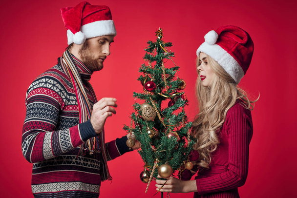 femme avec un arbre de Noël dans ses mains à côté d'un homme vacances famille Noël - Photo, image