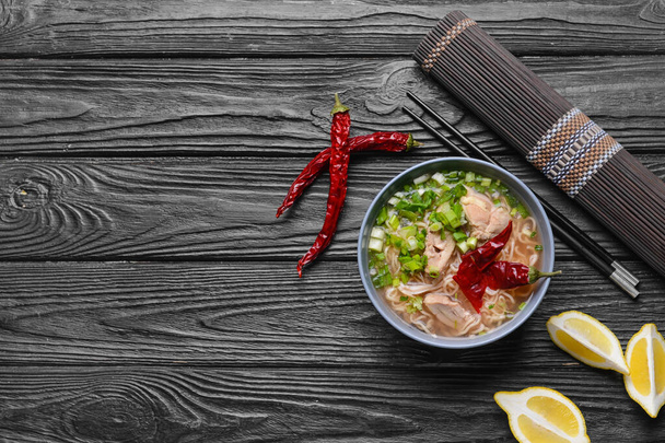 Kompozice s chutnou čínskou polévkou na tmavém dřevěném pozadí - Fotografie, Obrázek