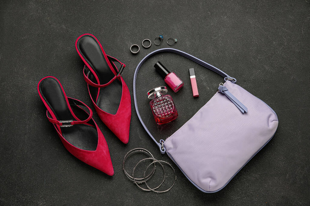 Composition with trendy handbag, shoes and different accessories on dark background - Photo, Image