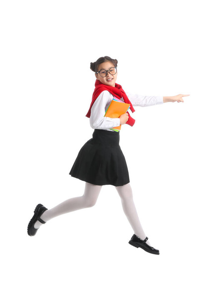Jumping little schoolgirl with notebooks on white background - Photo, Image