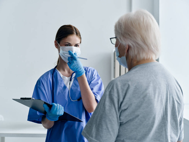 woman doctor with documents in hands and elderly woman patient vaccine passport immunity health - 写真・画像