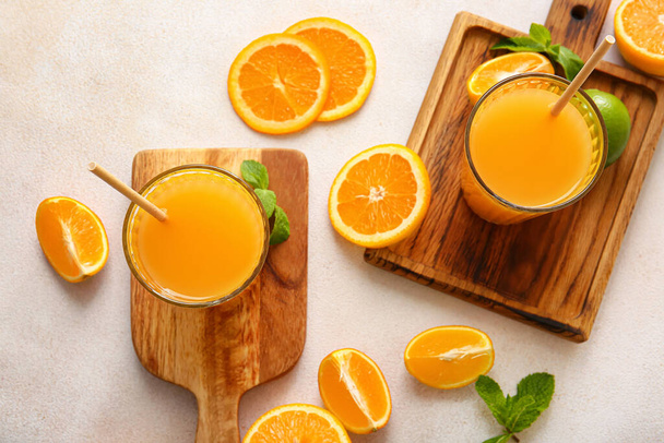 Vasos de sabroso jugo de naranja sobre fondo claro - Foto, imagen