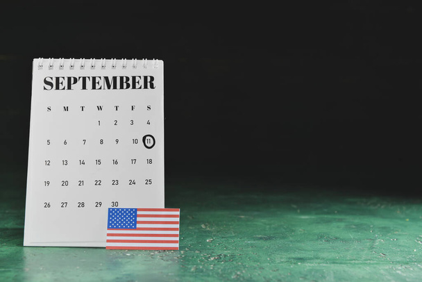 Calendario con data della Giornata Nazionale di Preghiera e Memoria per le Vittime degli Attacchi Terroristici con bandiera USA su sfondo scuro - Foto, immagini