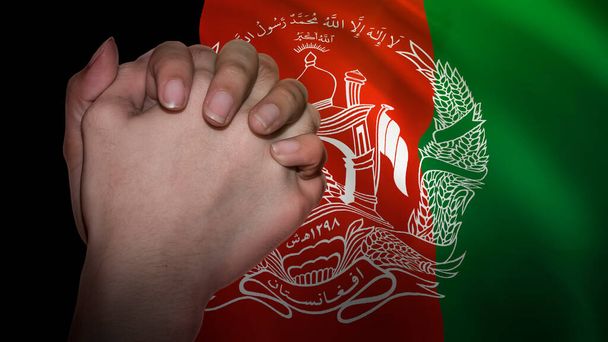 Ένα χέρι στην προσευχή μπροστά από τη σημαία του Αφγανιστάν. Προσεύχεται για τον αφγανικό λαό. - Φωτογραφία, εικόνα
