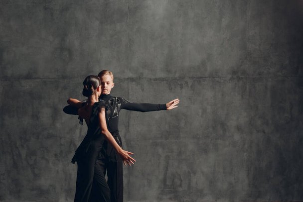 Νεαρό ζευγάρι σε μαύρη αίθουσα χορού Paso Doble. - Φωτογραφία, εικόνα