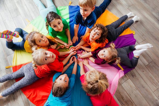 Happy kids laying on a floor in circle - Photo, image