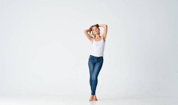 bonita rubia en jeans descalzo posando moda aislado fondo - Foto, Imagen
