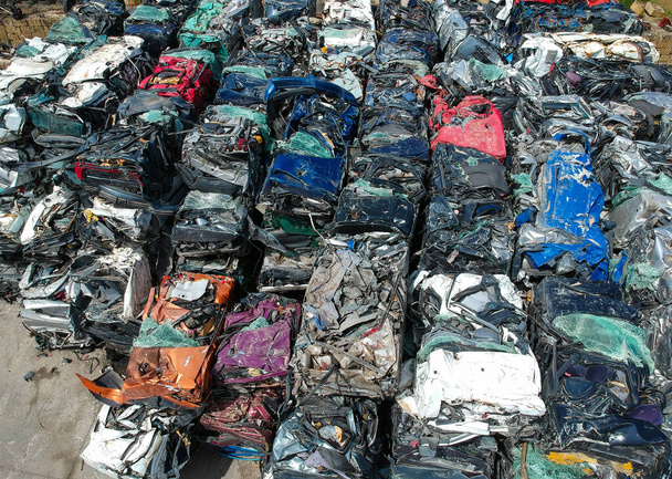 Autos auf dem Schrottplatz, gepresst und zum Recycling verpackt. Auto-Recycling - Foto, Bild
