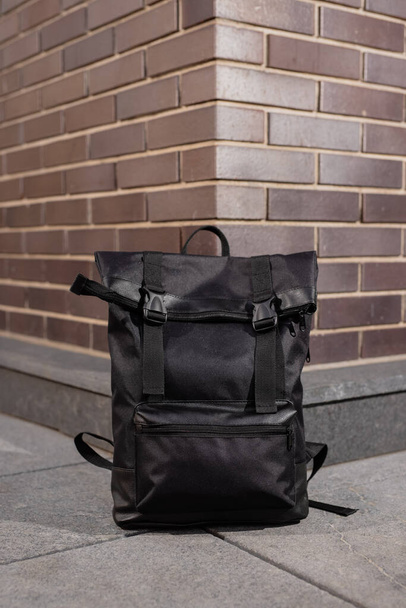 Fashionable black backpack near brick wall background - Photo, Image