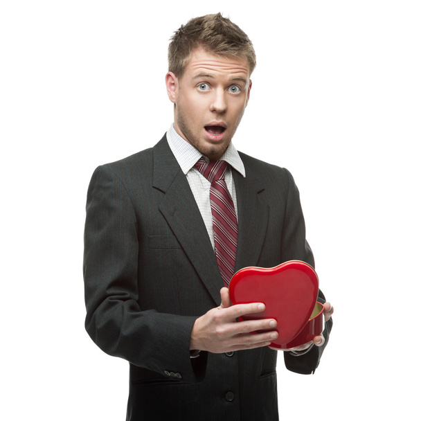 young surprised businessman holding red heart - Φωτογραφία, εικόνα