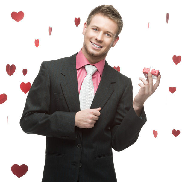 young cheerful businessman holding red gift - Foto, Imagen