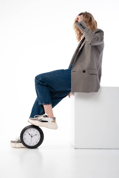 Deadline concept, time management. The woman stepped on the big clock. On white background. - Foto, Imagen