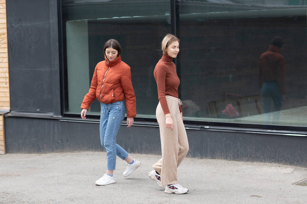 Two girls walking on the city street. Young woman outdoors. - Fotó, kép