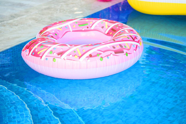 vacaciones de verano. Relájate junto a la piscina. Anillo inflable, rosado donut - Foto, Imagen