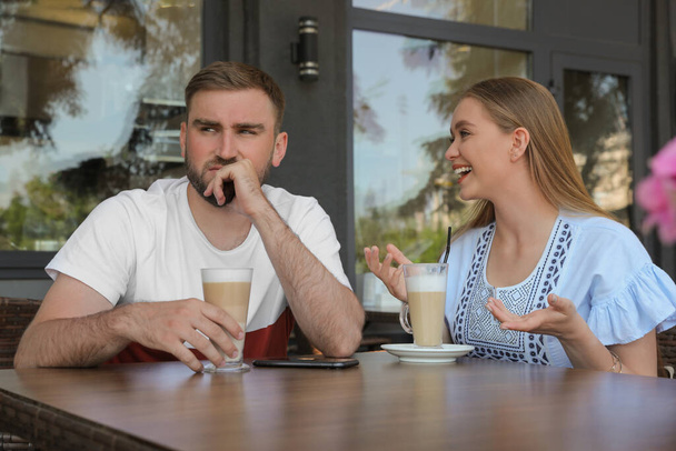Young man having boring date with talkative girl in outdoor cafe - Foto, Bild