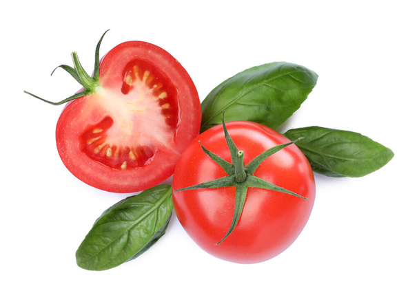 Fresh green basil leaves with cut and whole tomatoes on white background, top view - Foto, imagen