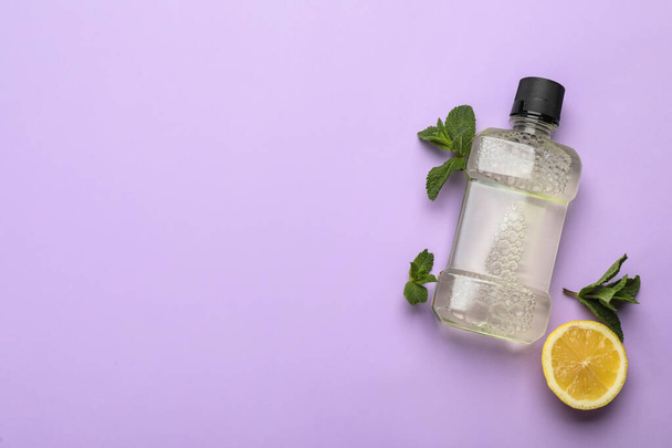 Mouthwash, mint and lemon on violet background, flat lay. Space for text - Фото, изображение